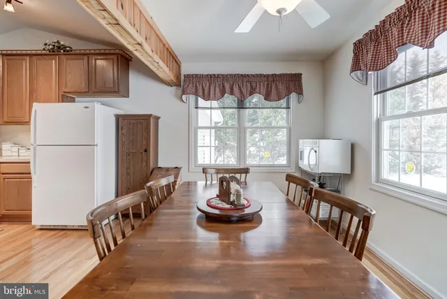 a dining room with furniture a chandelier and wooden floor