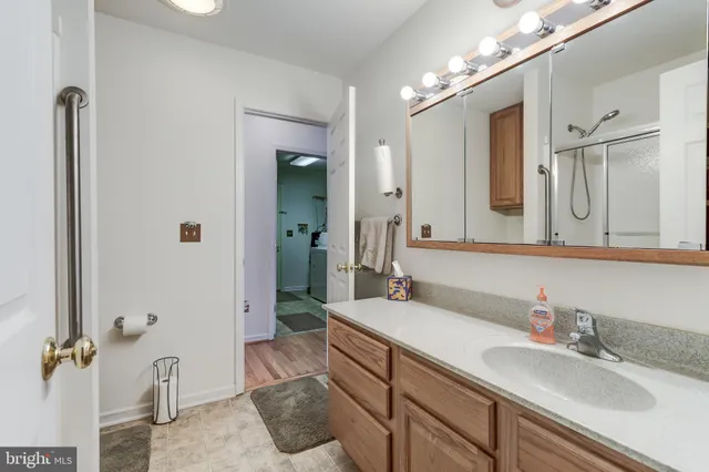 a spacious bathroom with a granite countertop sink a mirror and shower