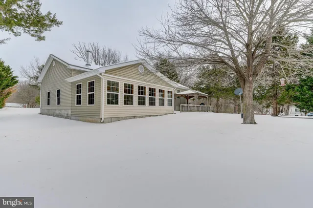 a view of a house with a yard covered in snow