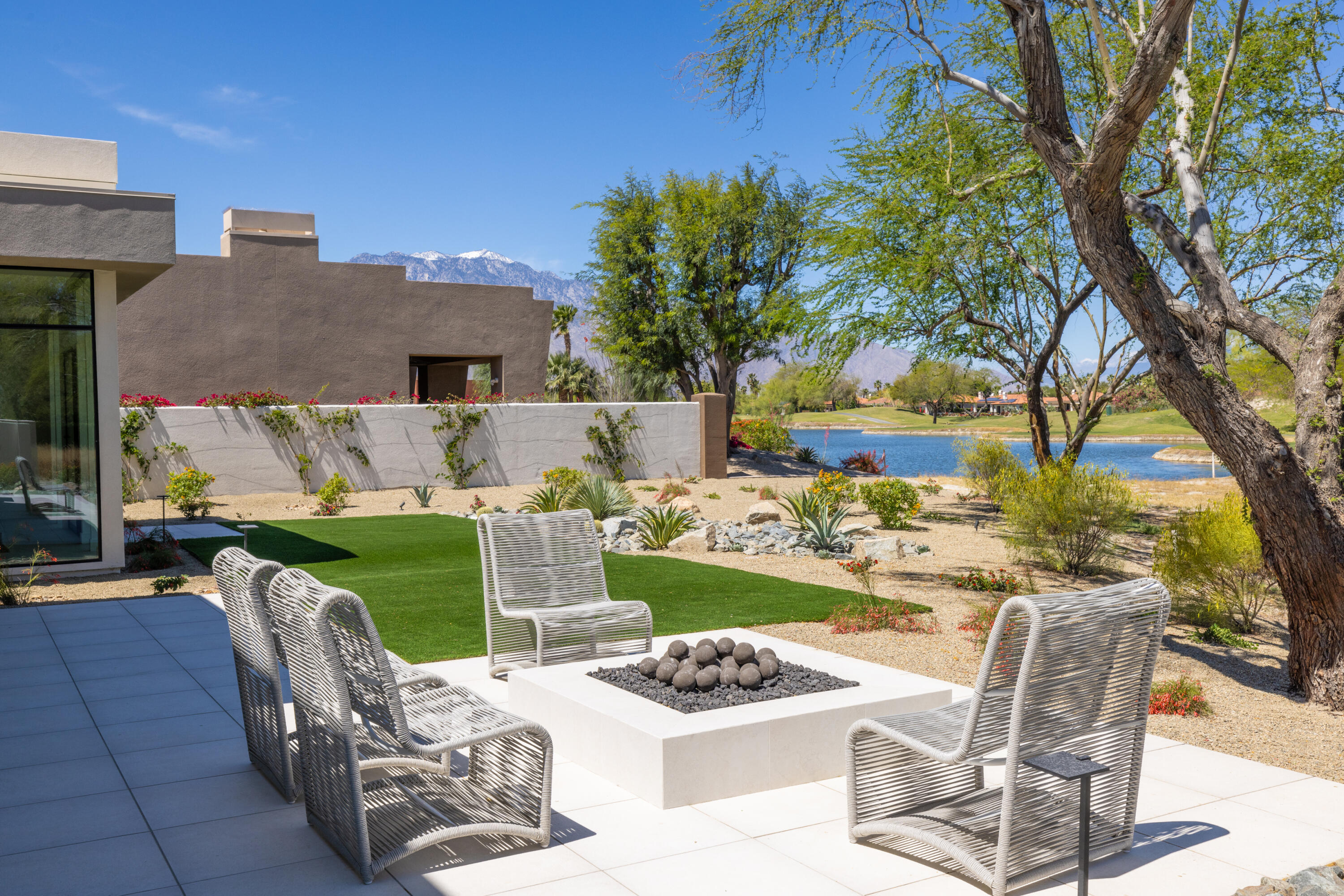 96 Royal St Georges Way Rancho Mirage, CA 92270 - Photo 27 of 34 a view of a backyard with table and chairs potted plants and a fire pit
