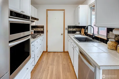 a kitchen with stainless steel appliances a stove a sink and a refrigerator
