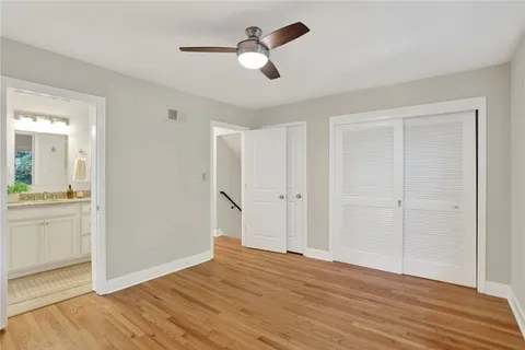 a view of empty room with wooden floor and ceiling fan