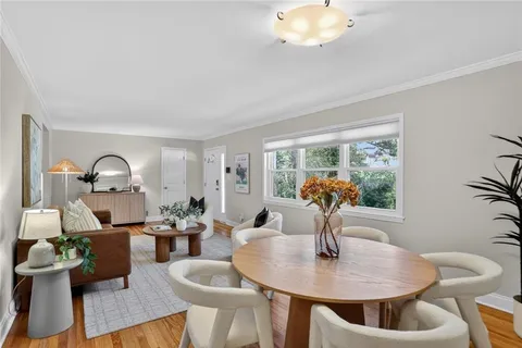 a dining room with furniture a potted plant and a chandelier