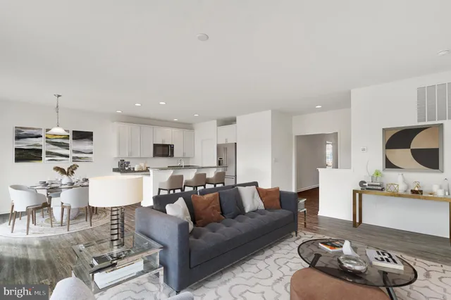 a living room with furniture kitchen view and a chandelier