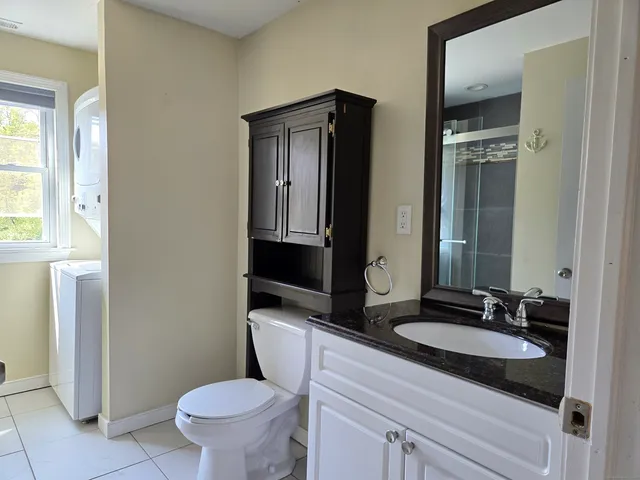 a bathroom with a granite countertop sink toilet and mirror