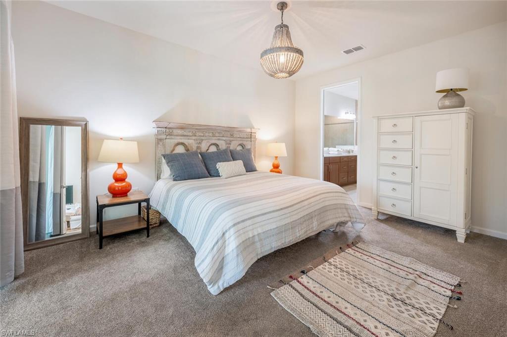 4720 Arboretum Circle, Unit 102 Naples, FL 34112 - Photo 16 of 44 a bedroom with a bed and a chandelier