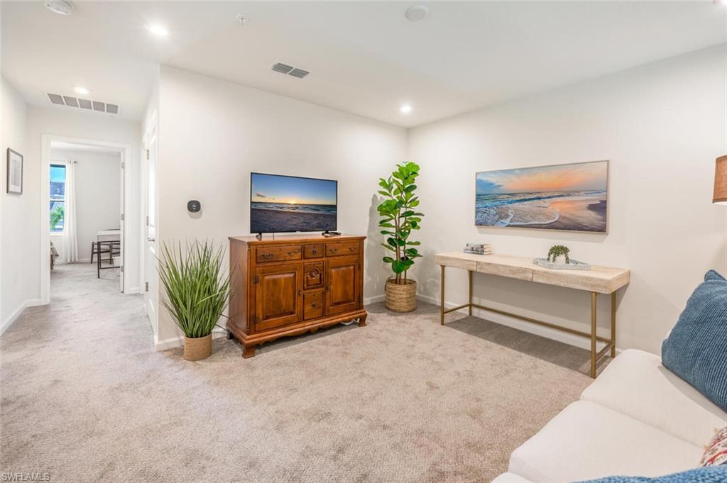 4720 Arboretum Circle, Unit 102 Naples, FL 34112 - Photo 19 of 44 a living room with furniture and a flat screen tv
