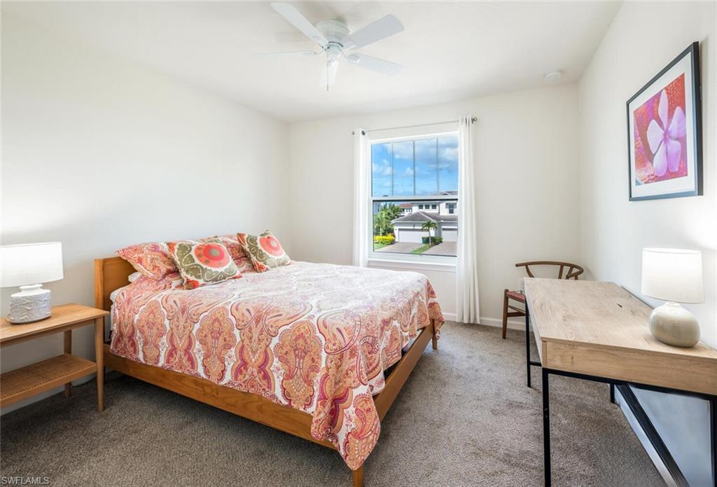 4720 Arboretum Circle, Unit 102 Naples, FL 34112 - Photo 24 of 44 a bedroom with a bed and a table in it
