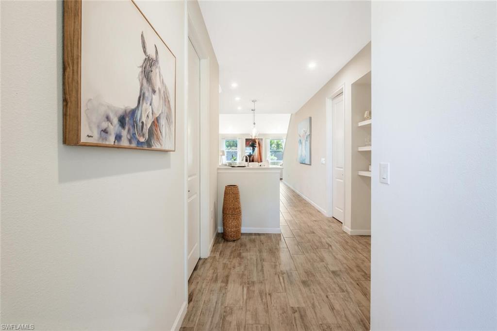 4720 Arboretum Circle, Unit 102 Naples, FL 34112 - Photo 3 of 44 a view of a hallway with wooden floor and a refrigerator