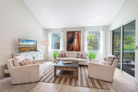 a living room with furniture and a painting on the wall