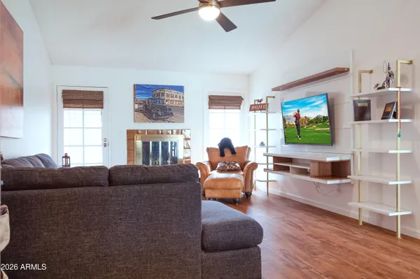 a living room with furniture a flat screen tv and a window