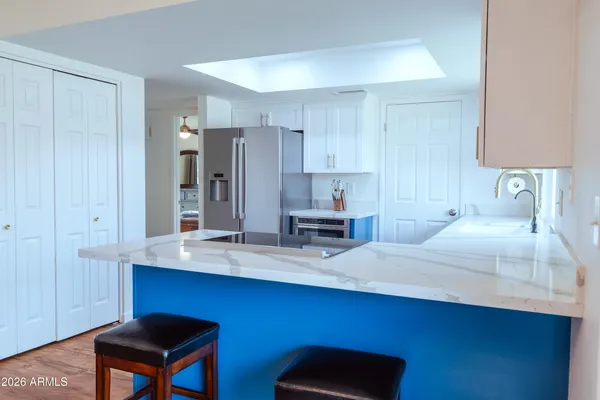 a kitchen with stainless steel appliances a sink cabinets and wooden floor