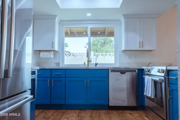 a kitchen with granite countertop a sink a stove and cabinets