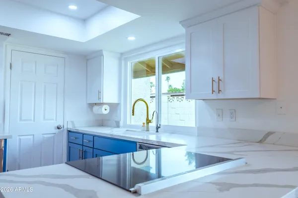 a kitchen that has a sink a window in it and wooden cabinets