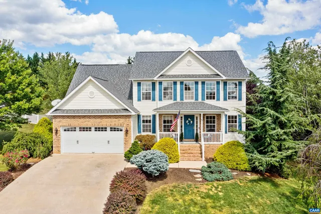 a front view of a house with a yard and potted plants