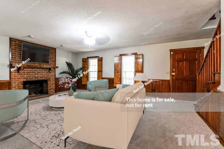 6587 Dwight Rowland Road Willow Spring, NC 27592 - Photo 2 of 25 a living room with furniture a fireplace and a flat screen tv