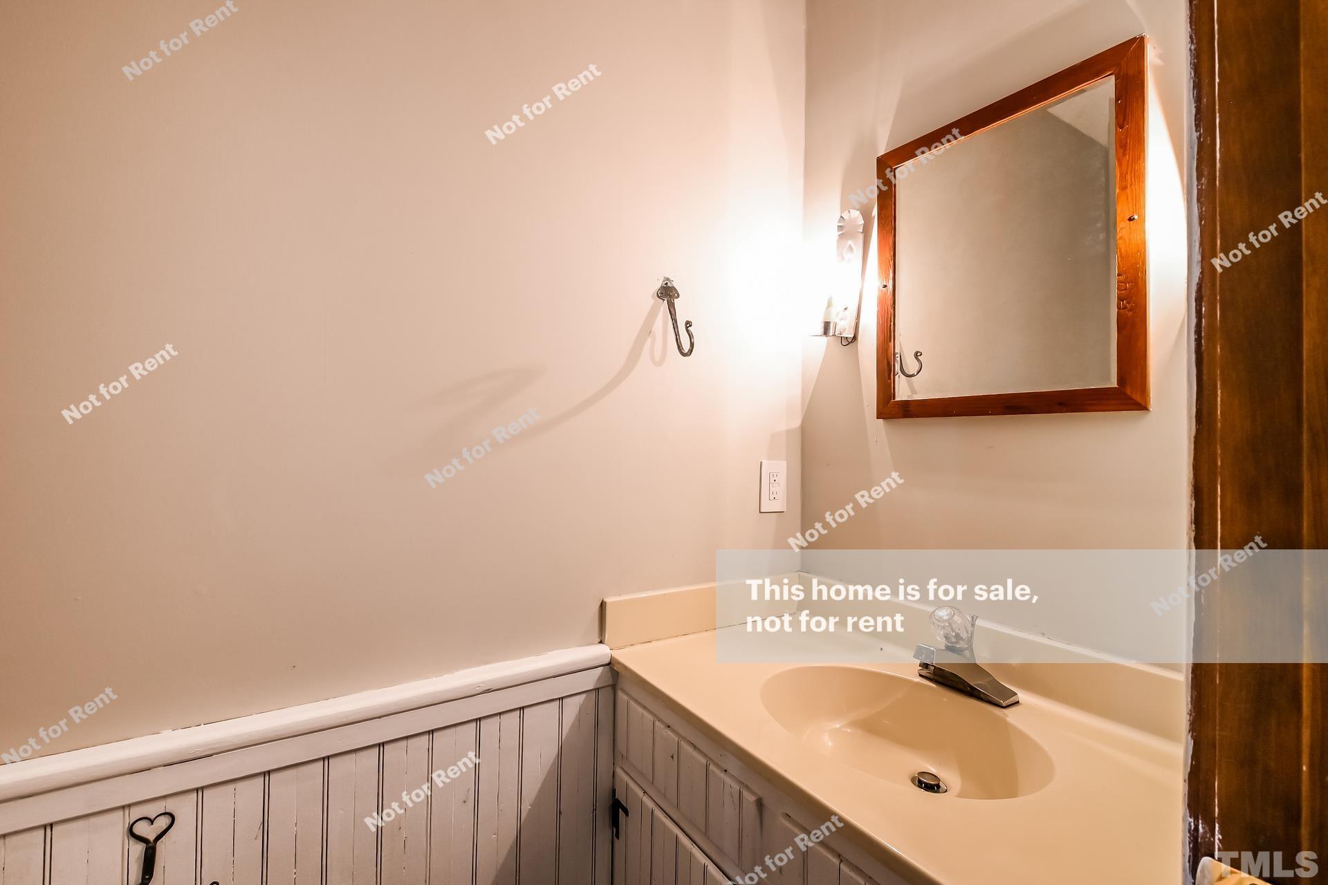 6587 Dwight Rowland Road Willow Spring, NC 27592 - Photo 19 of 25 a bathroom with a sink and a mirror