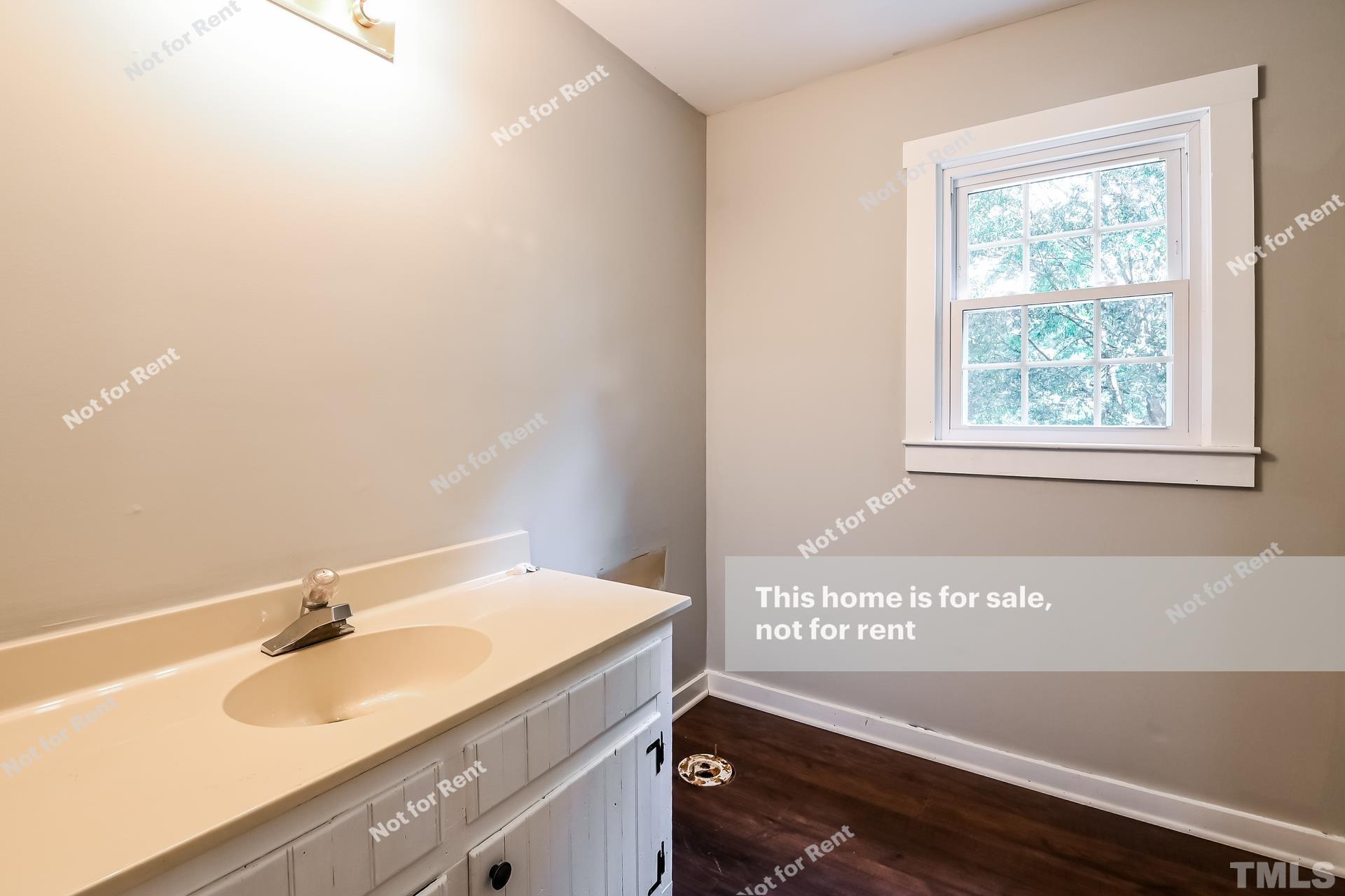 6587 Dwight Rowland Road Willow Spring, NC 27592 - Photo 20 of 25 a view of a bathroom with a sink and a window
