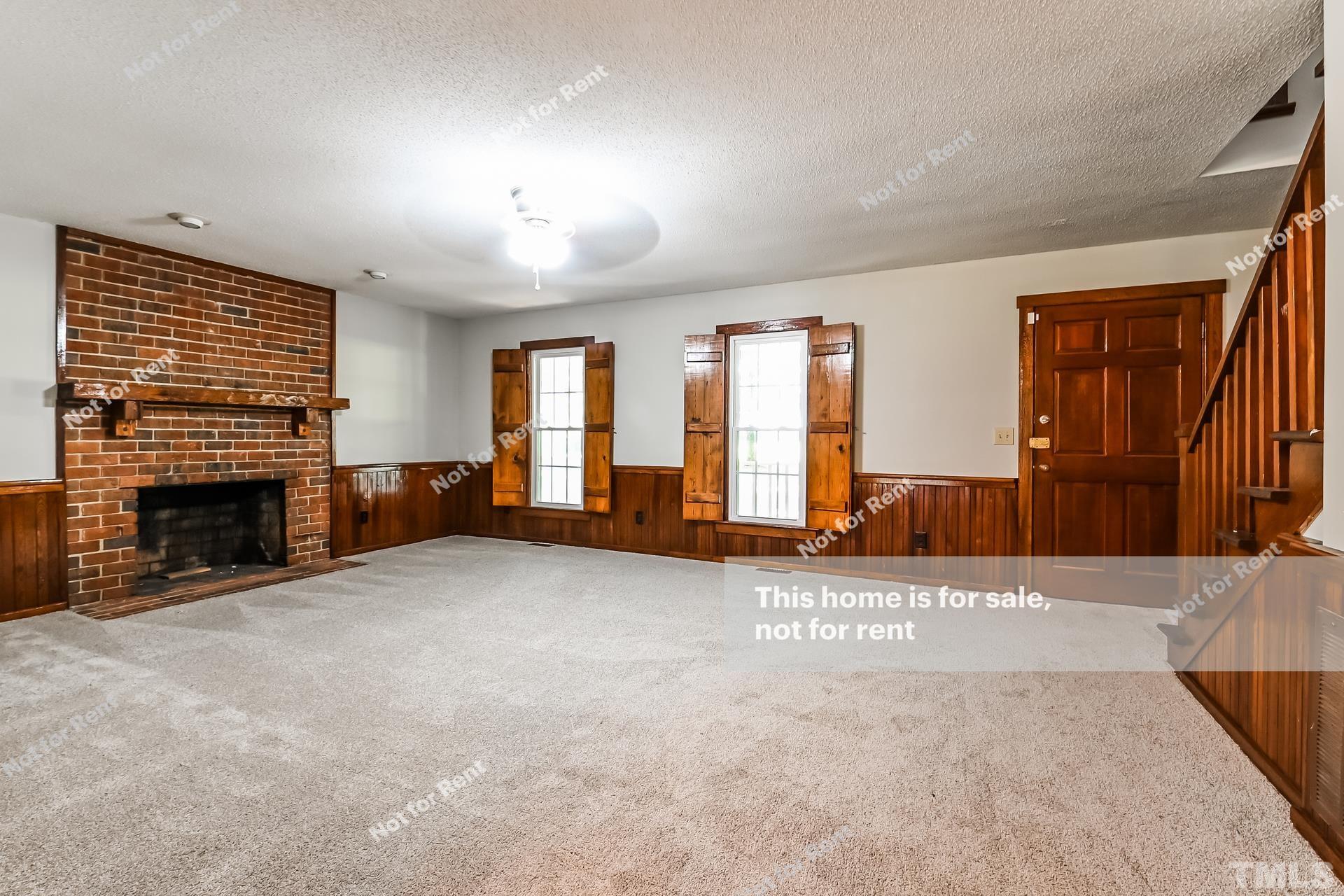 6587 Dwight Rowland Road Willow Spring, NC 27592 - Photo 5 of 25 an empty room with windows and fireplace