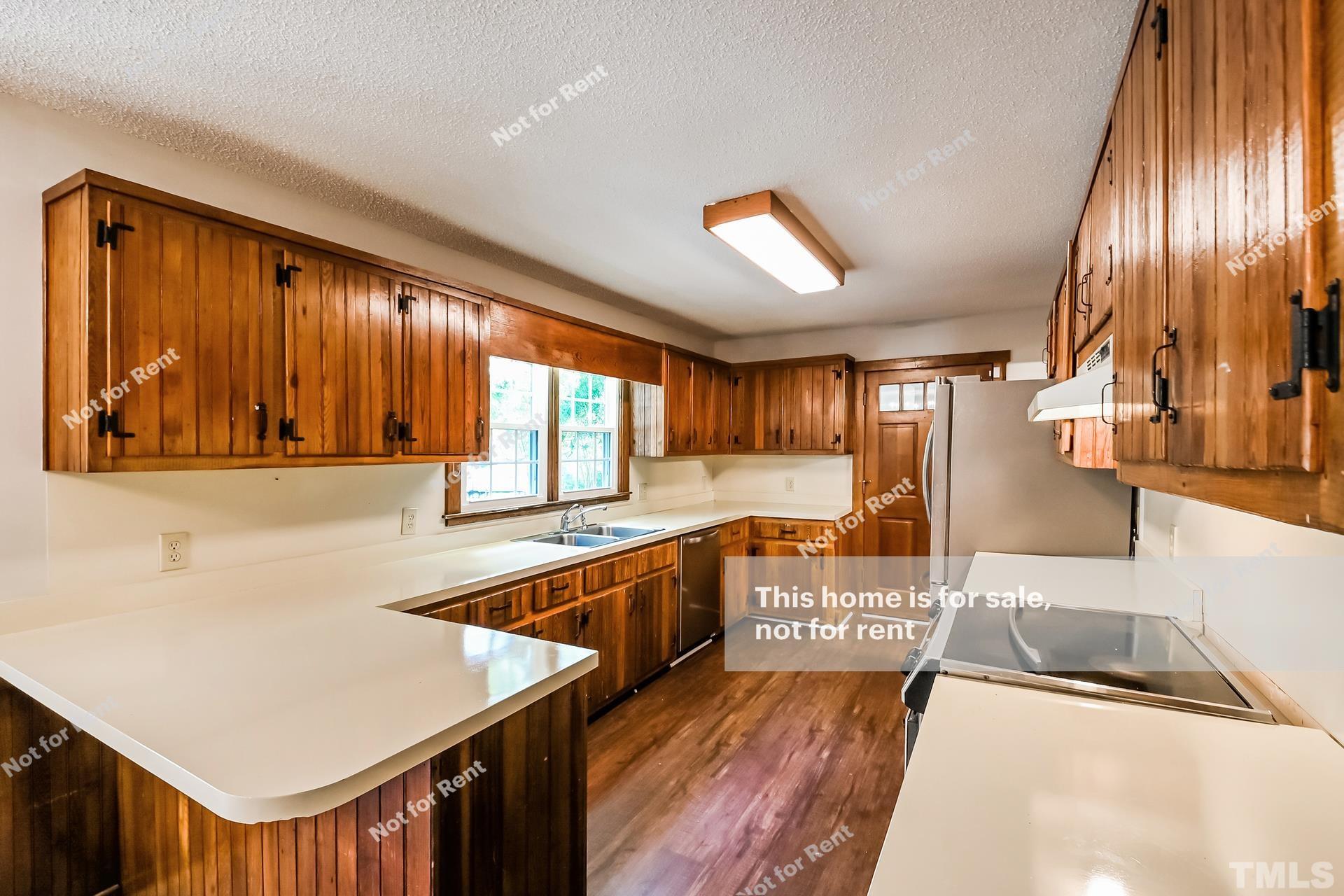 6587 Dwight Rowland Road Willow Spring, NC 27592 - Photo 10 of 25 a kitchen with a stove a sink and a refrigerator