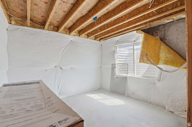 2567 West Rim Rock Drive Stockton, UT 84071 - Photo 39 of 64 Unfinished basement space featuring exposed wood joists, insulation, a window with venetian blinds, concrete flooring, and wrapped walls