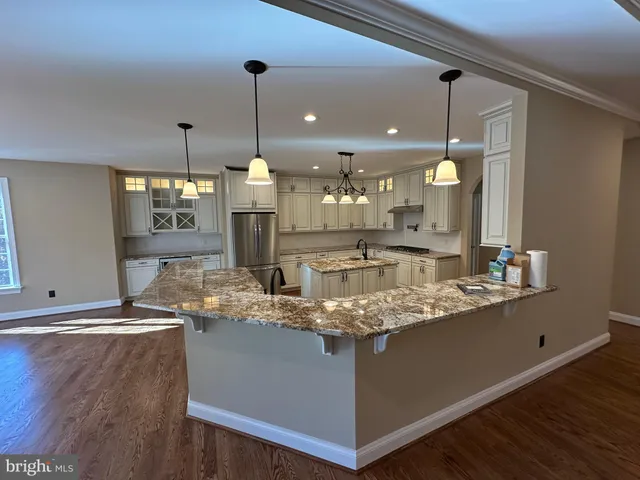 a kitchen with kitchen island granite countertop a large counter top stainless steel appliances and cabinets