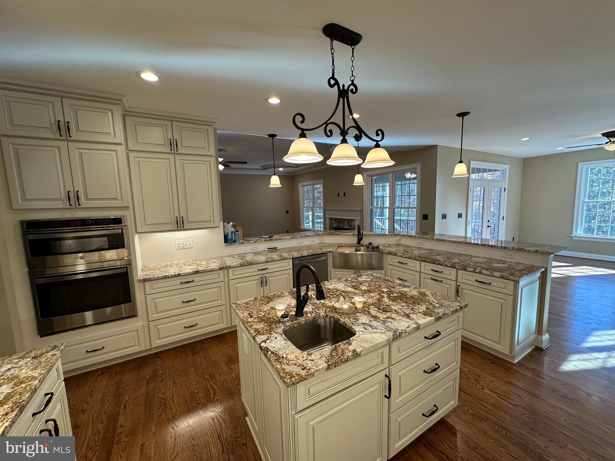 1 Keval Gyan Way Winchester, VA 22603 - Photo 25 of 48 a kitchen with kitchen island granite countertop a stove and a wooden floors