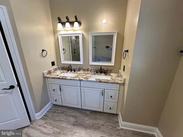 a bathroom with a double vanity sink and mirror