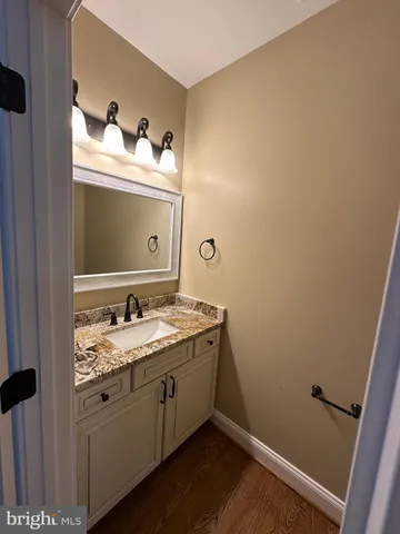 a bathroom with a granite countertop sink toilet and vanity