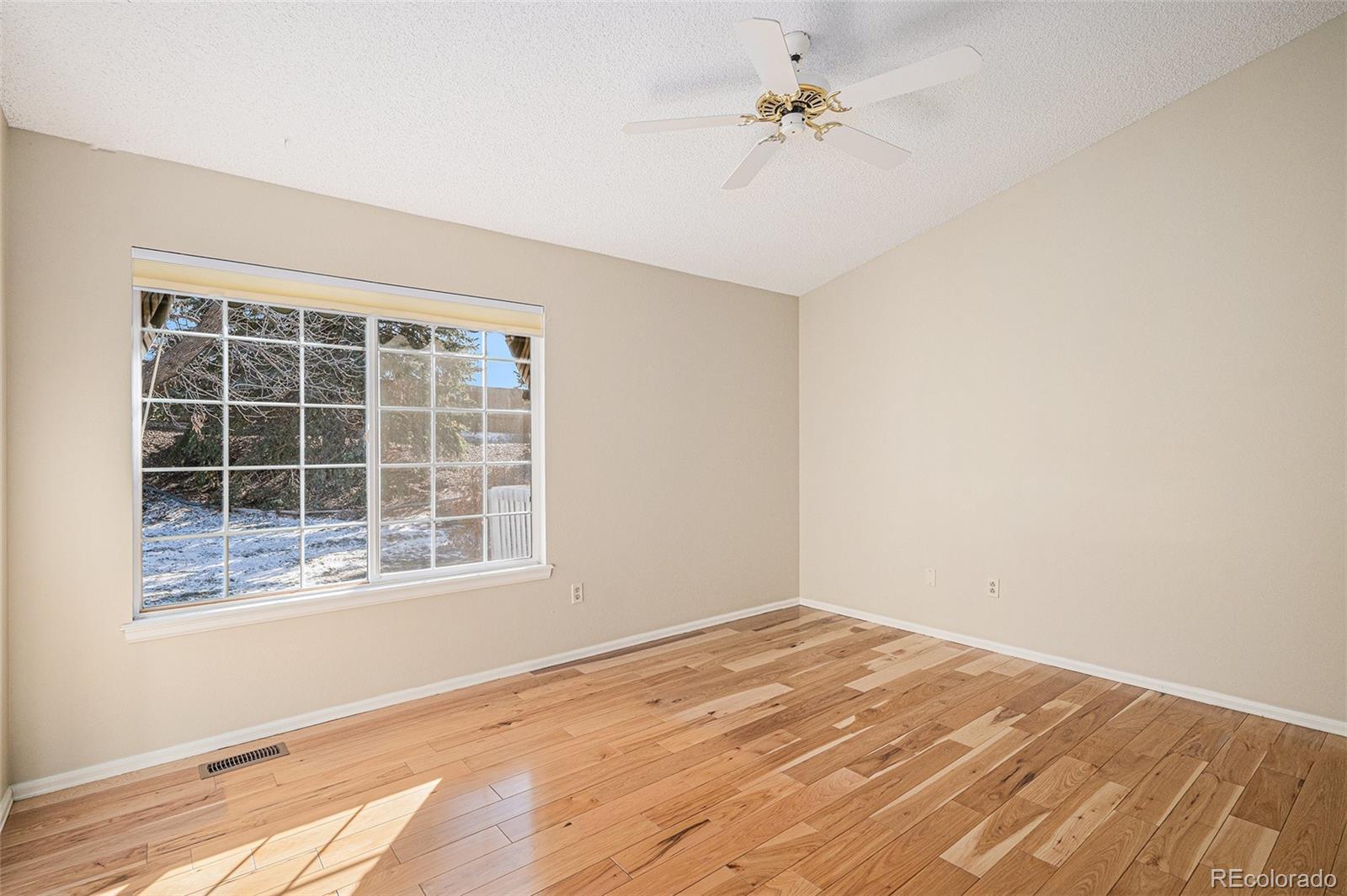 16 Shetland Court Highlands Ranch, CO 80130 - Photo 15 of 25 a view of empty room with wooden floor and fan