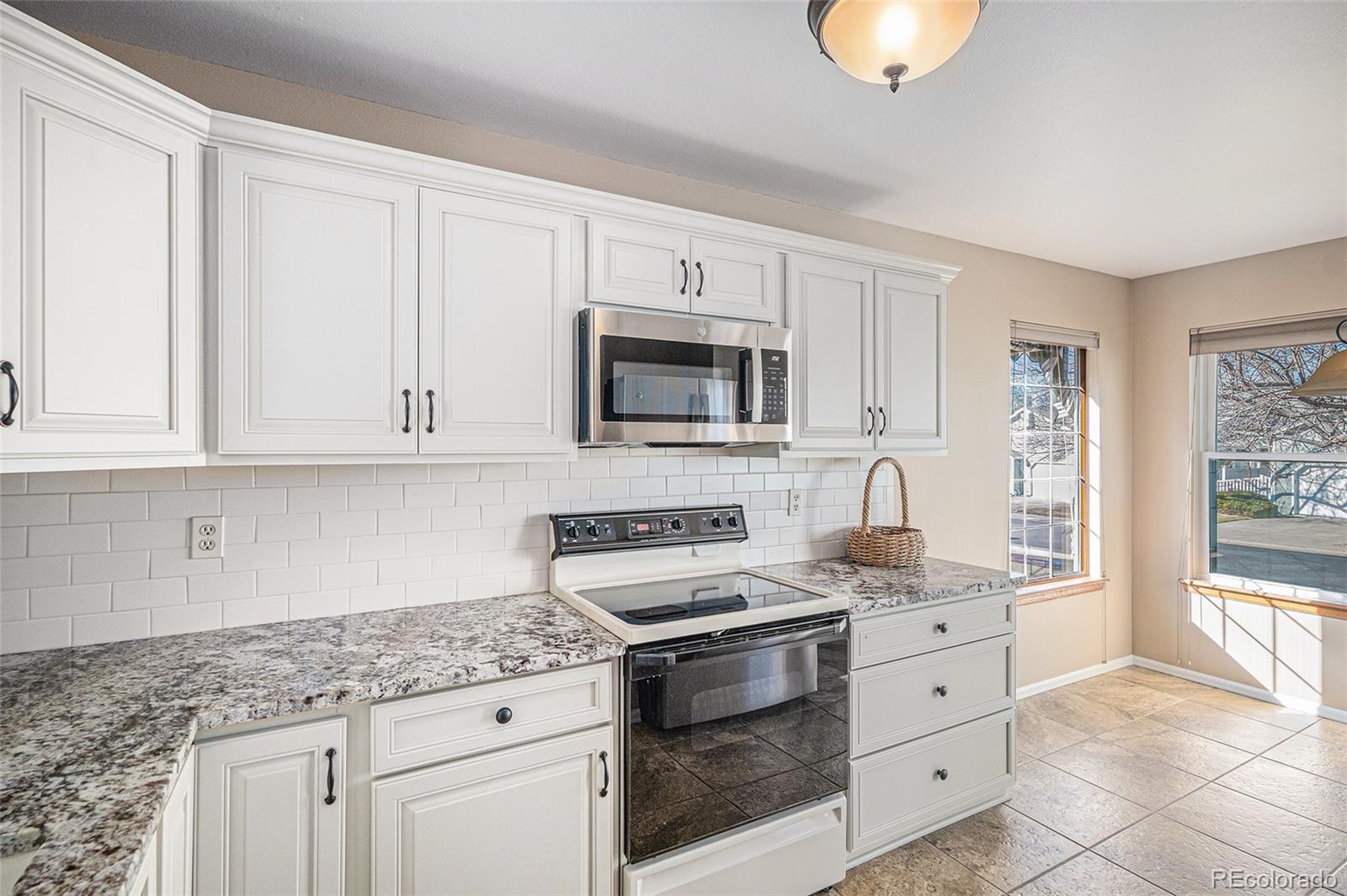 16 Shetland Court Highlands Ranch, CO 80130 - Photo 5 of 25 a kitchen with granite countertop white cabinets and stainless steel appliances