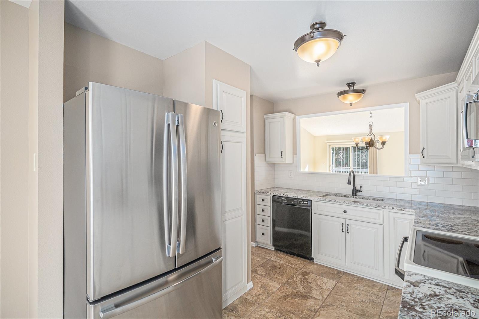 16 Shetland Court Highlands Ranch, CO 80130 - Photo 6 of 25 a kitchen with stainless steel appliances granite countertop a refrigerator and a sink