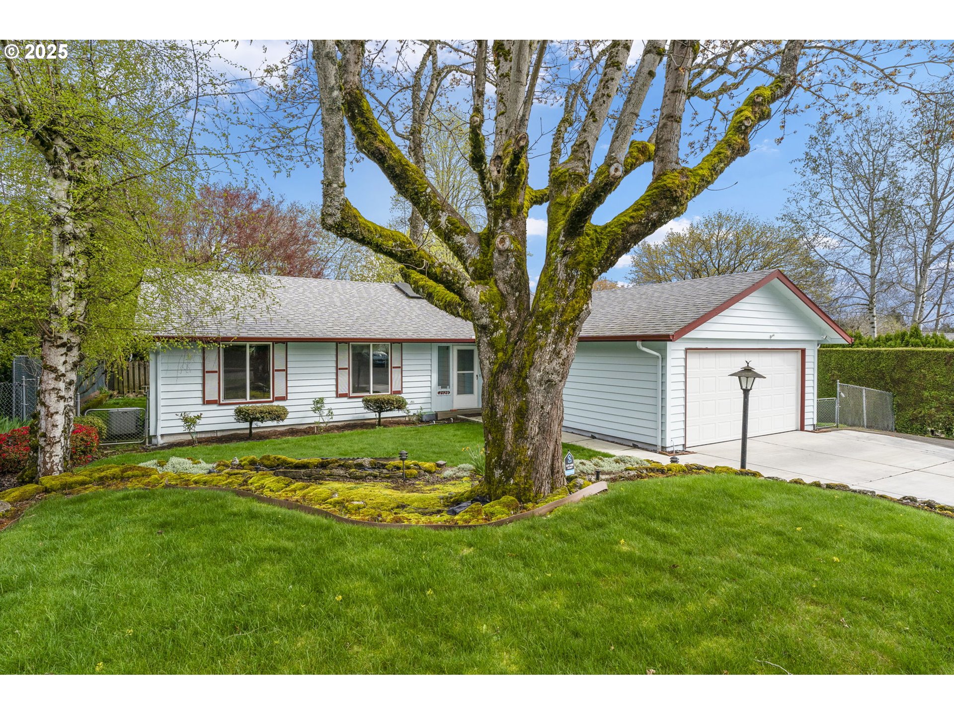 2320 Northeast Juniper Avenue Gresham, OR 97030 - Photo 2 of 34 a front view of a house with a garden and trees