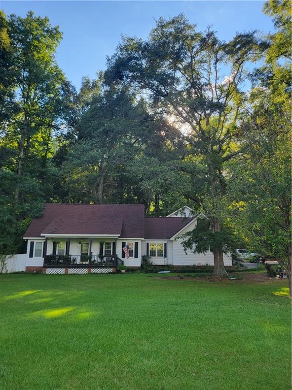 a view of a big house with garden and a tree