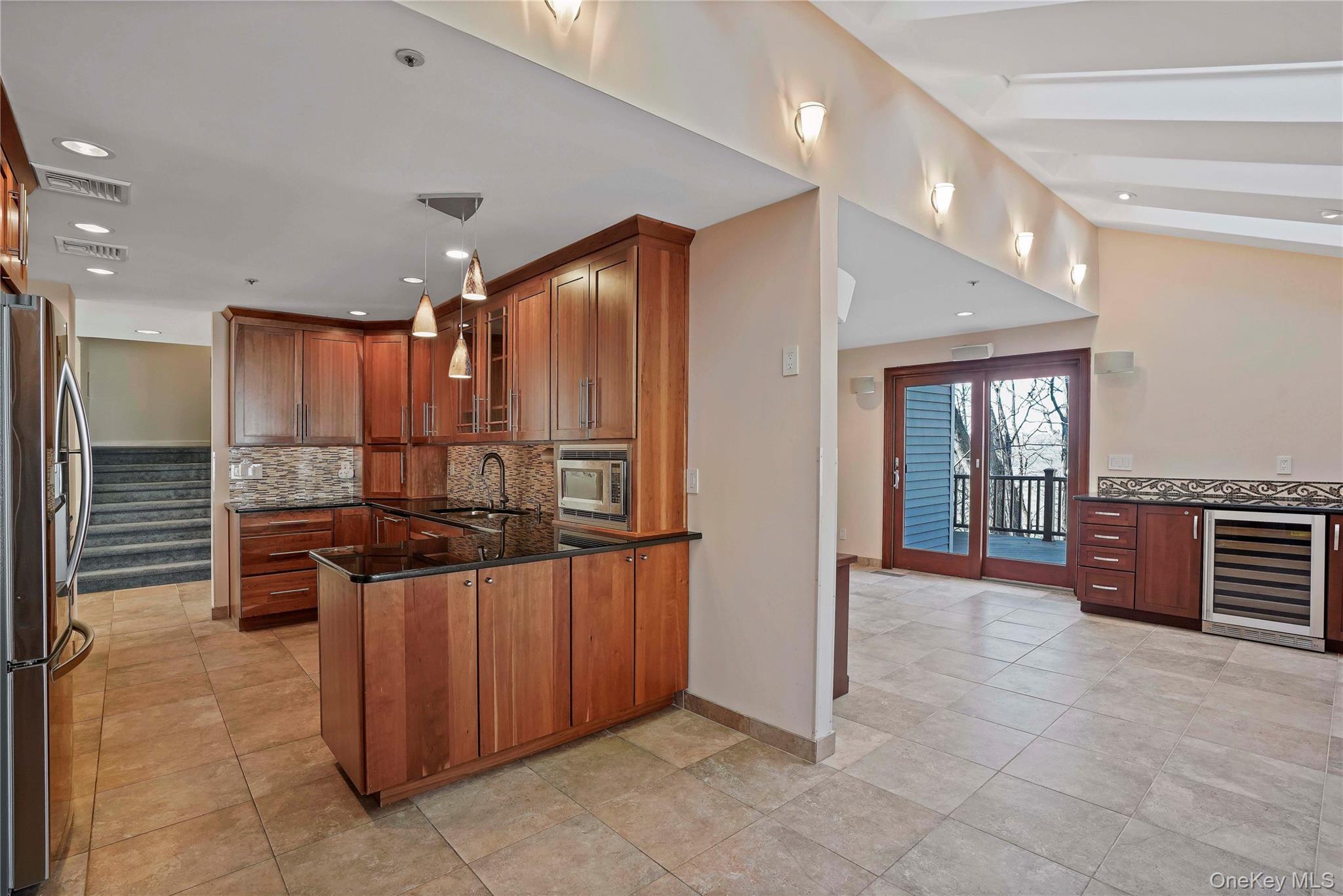 208 Boulder Ridge Road Scarsdale, NY 10583 - Photo 7 of 43 Kitchen with dark stone countertops, glass insert cabinets, a peninsula, beverage cooler, and stainless steel appliances