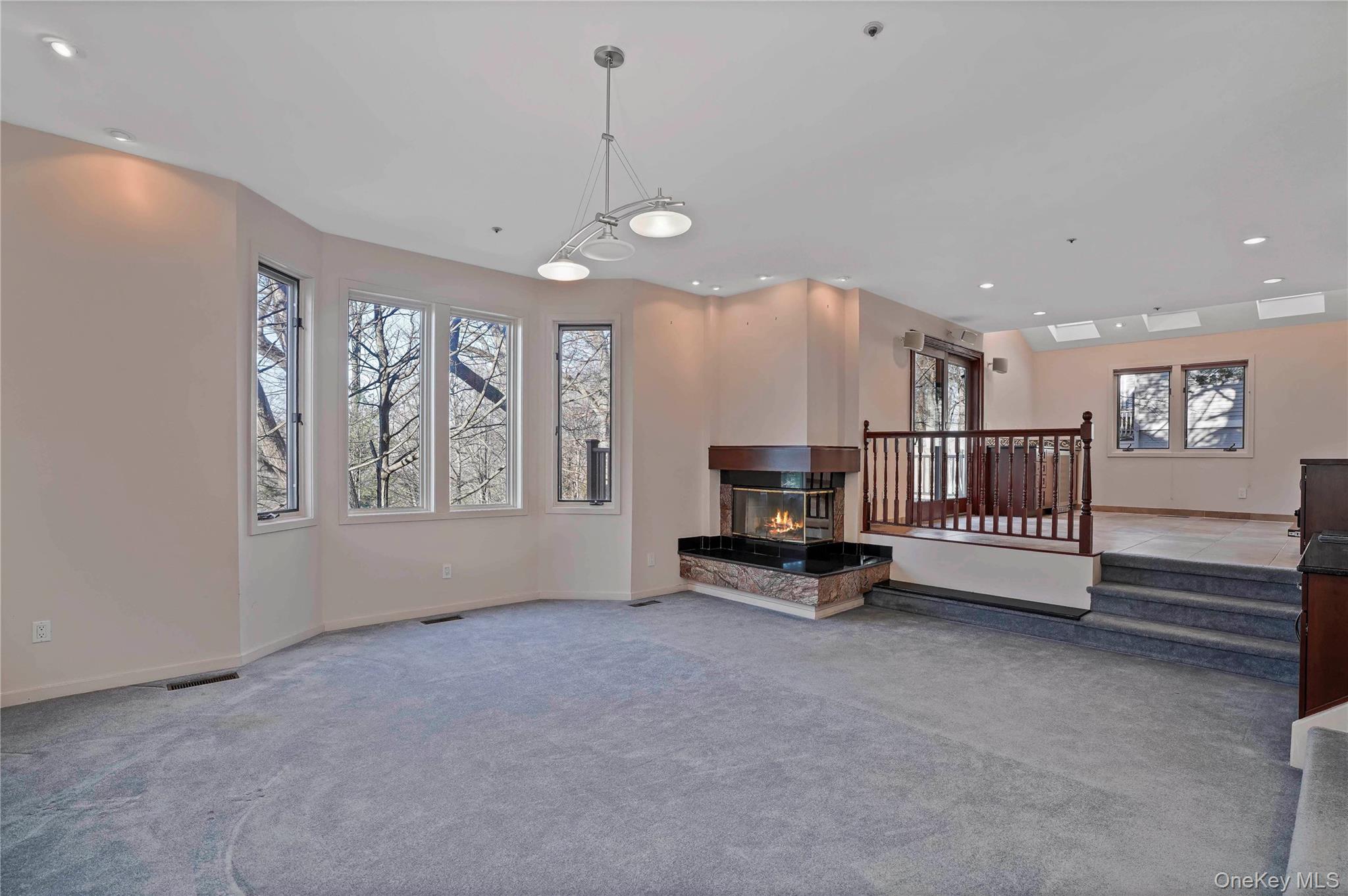 208 Boulder Ridge Road Scarsdale, NY 10583 - Photo 10 of 43 Unfurnished living room featuring recessed lighting, carpet flooring, and a multi sided fireplace