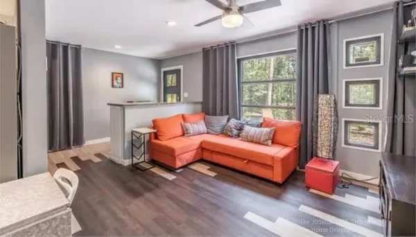 a living room with furniture and a wooden floor