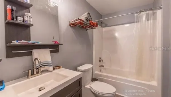 a bathroom with a sink a toilet and shower curtain