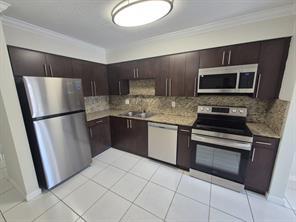 a kitchen with stainless steel appliances granite countertop a refrigerator sink and microwave
