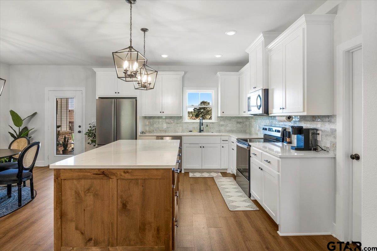 681 Peavine Road Kilgore, TX 75662 - Photo 11 of 27 a kitchen with kitchen island a white counter top space a sink cabinets and stainless steel appliances