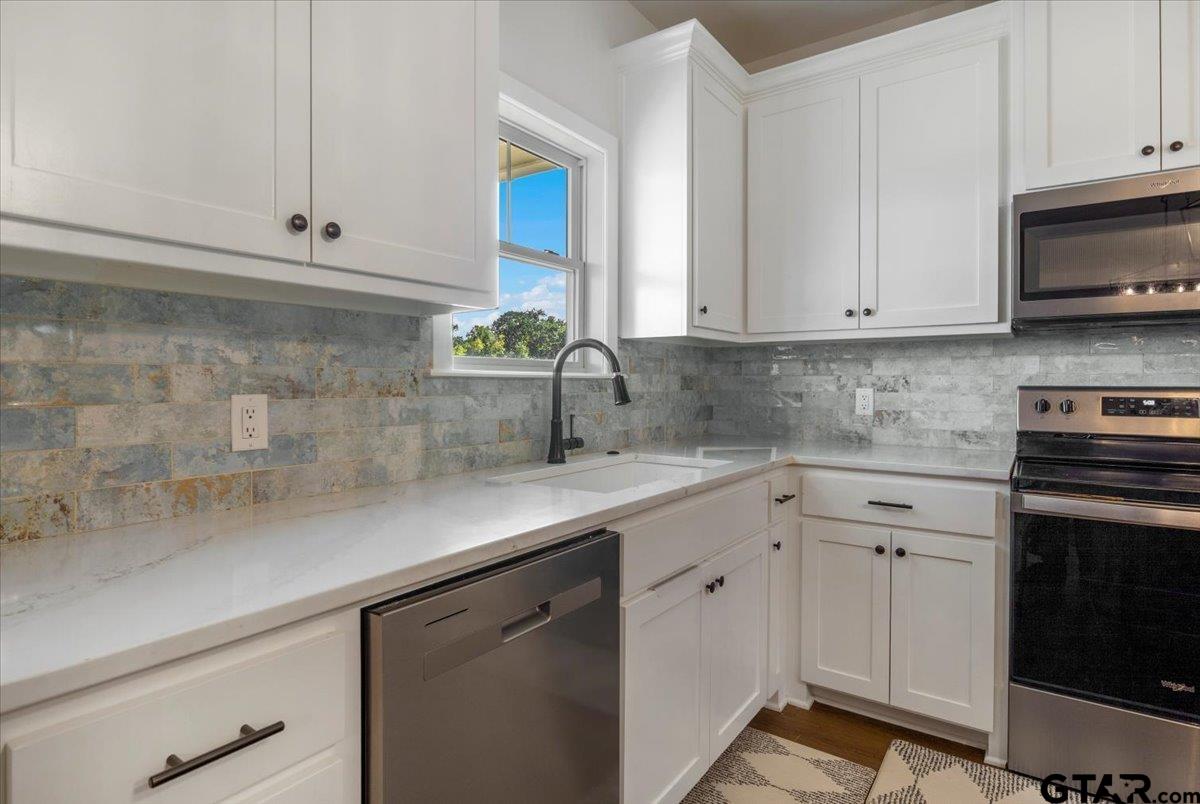 681 Peavine Road Kilgore, TX 75662 - Photo 13 of 27 a kitchen with white cabinets and white appliances