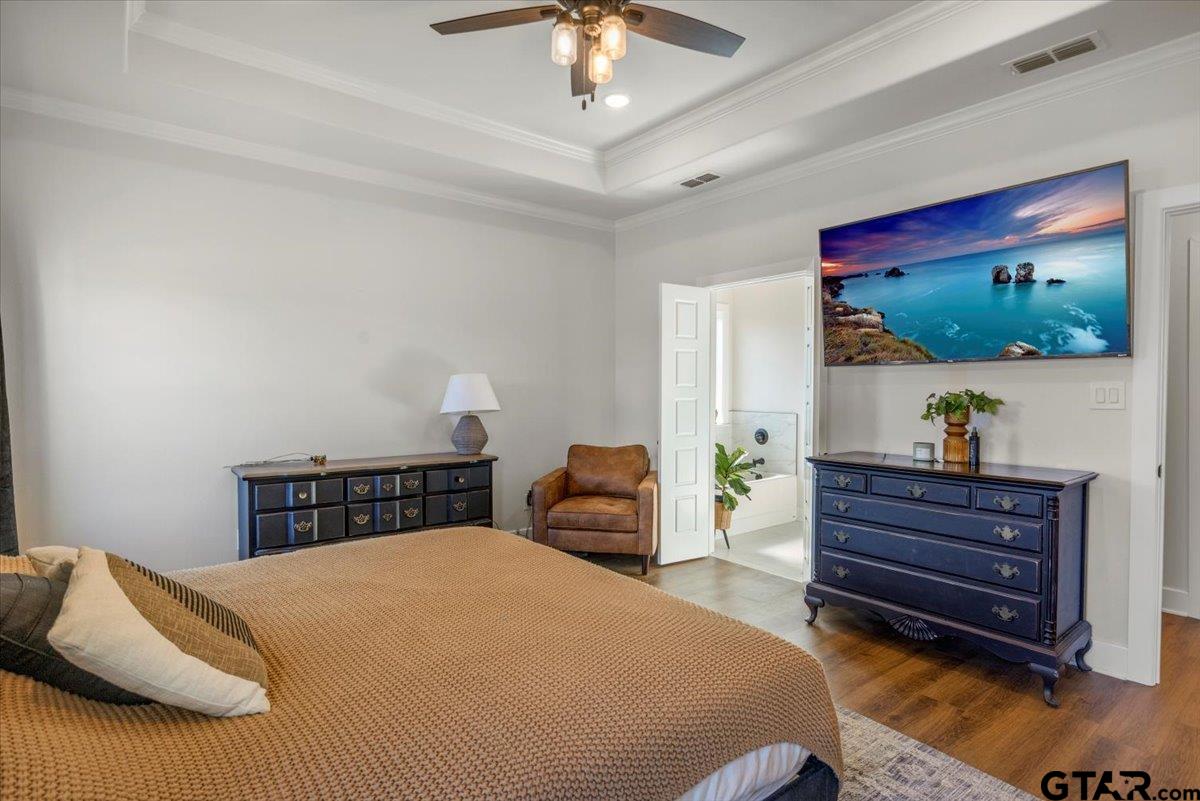 681 Peavine Road Kilgore, TX 75662 - Photo 17 of 27 a bedroom with a bed and a chandelier