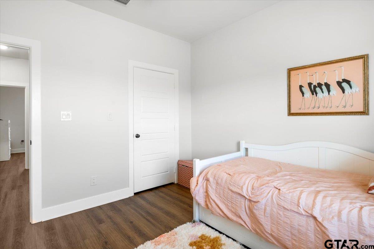 681 Peavine Road Kilgore, TX 75662 - Photo 25 of 27 a bedroom with a bed and a painting on the wall