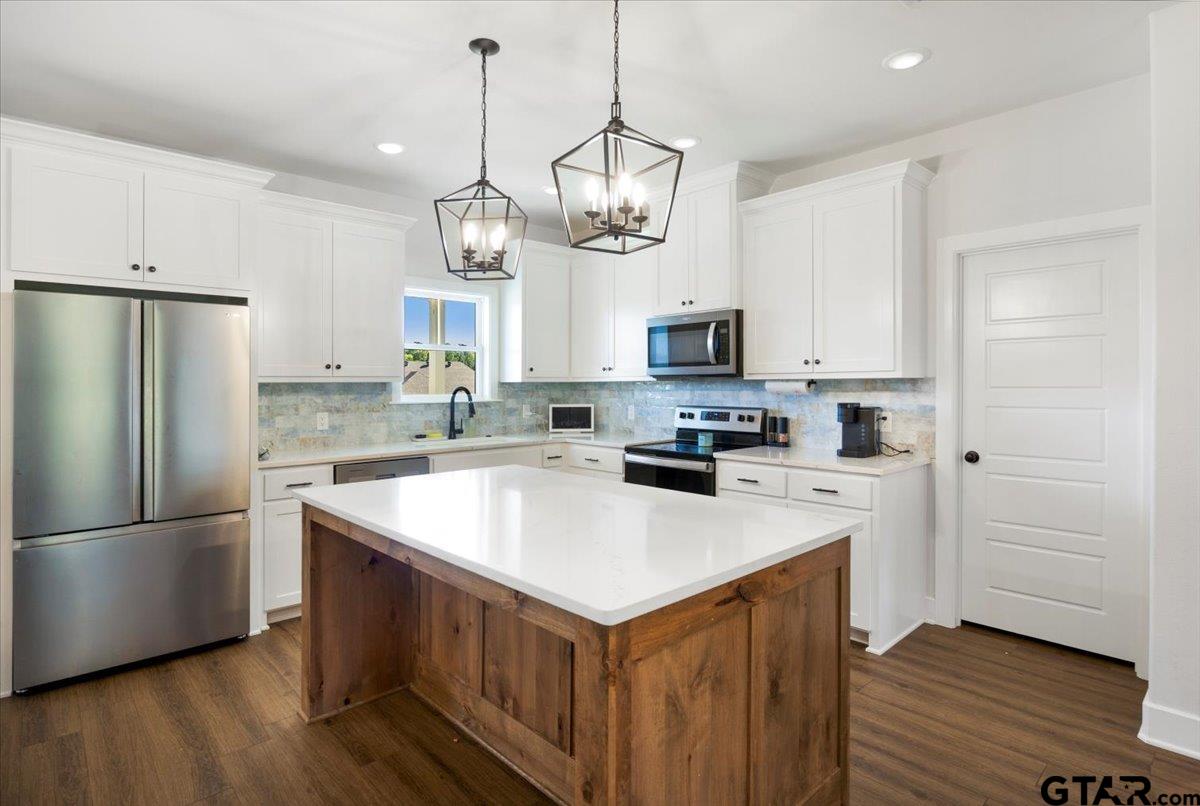 681 Peavine Road Kilgore, TX 75662 - Photo 10 of 27 a kitchen with stainless steel appliances granite countertop a refrigerator a sink dishwasher a stove and a refrigerator with wooden floor
