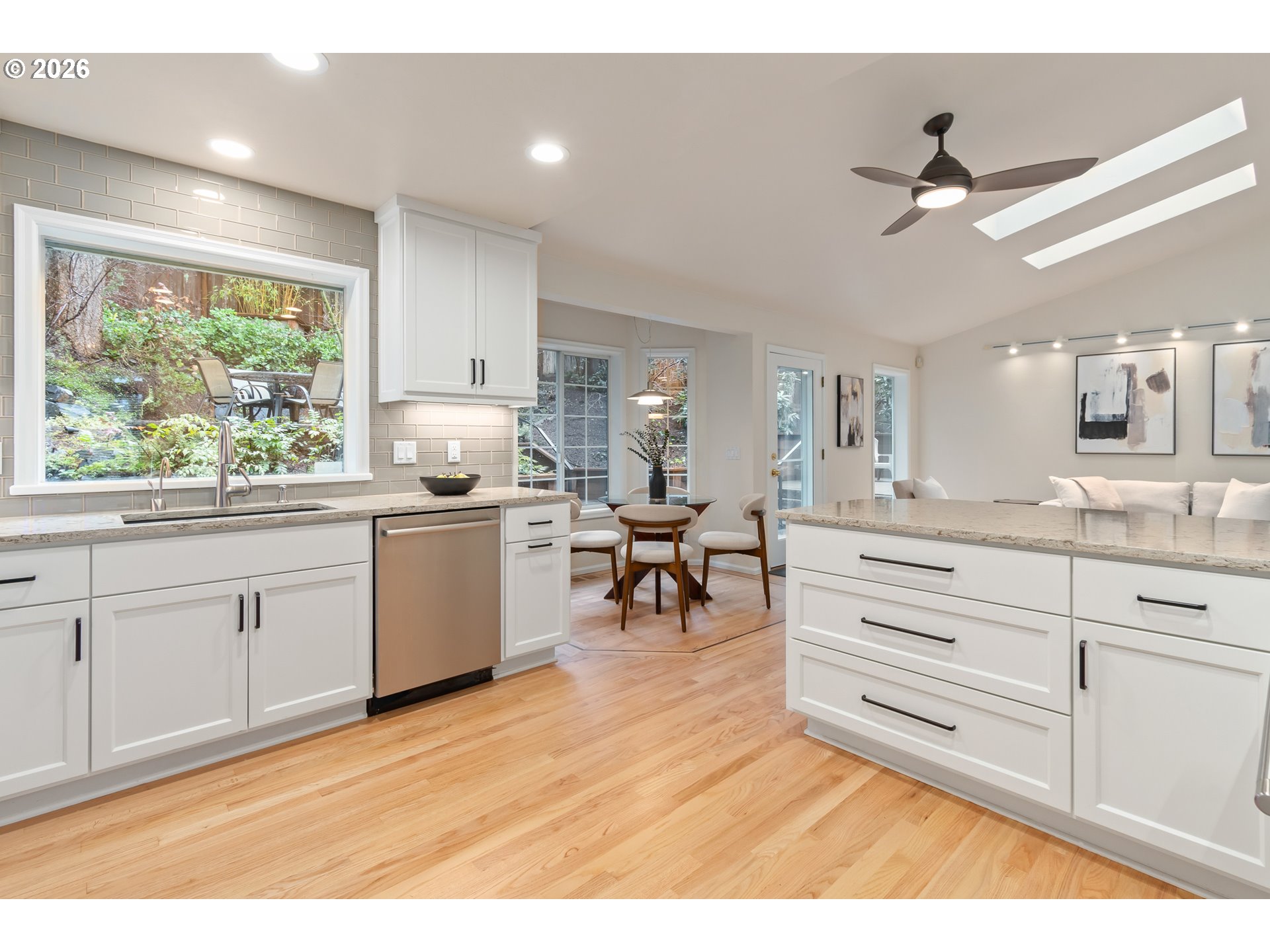 2380 West 28th Avenue Eugene, OR 97405 - Photo 10 of 48 a kitchen with granite countertop a stove a sink and white cabinets with wooden floor