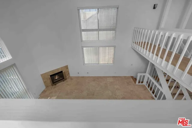 a view of an empty room with wooden floor and bedroom