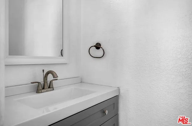 a view of an empty room with wooden floor and window