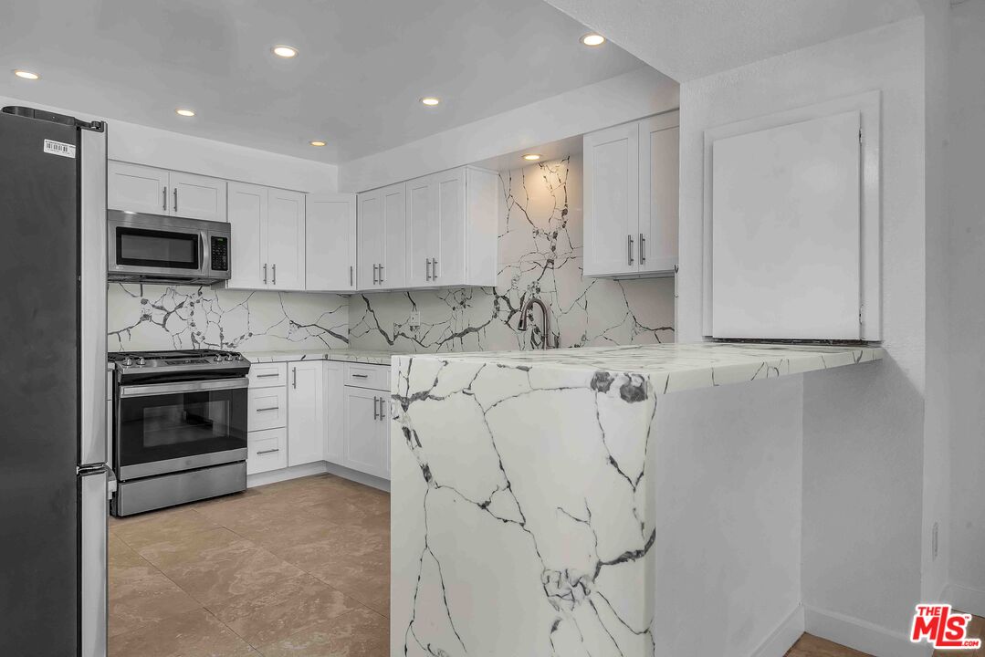 15 63rd Avenue, Unit 3 Playa del Rey, CA 90293 - Photo 8 of 34 a kitchen with white cabinets and stainless steel appliances