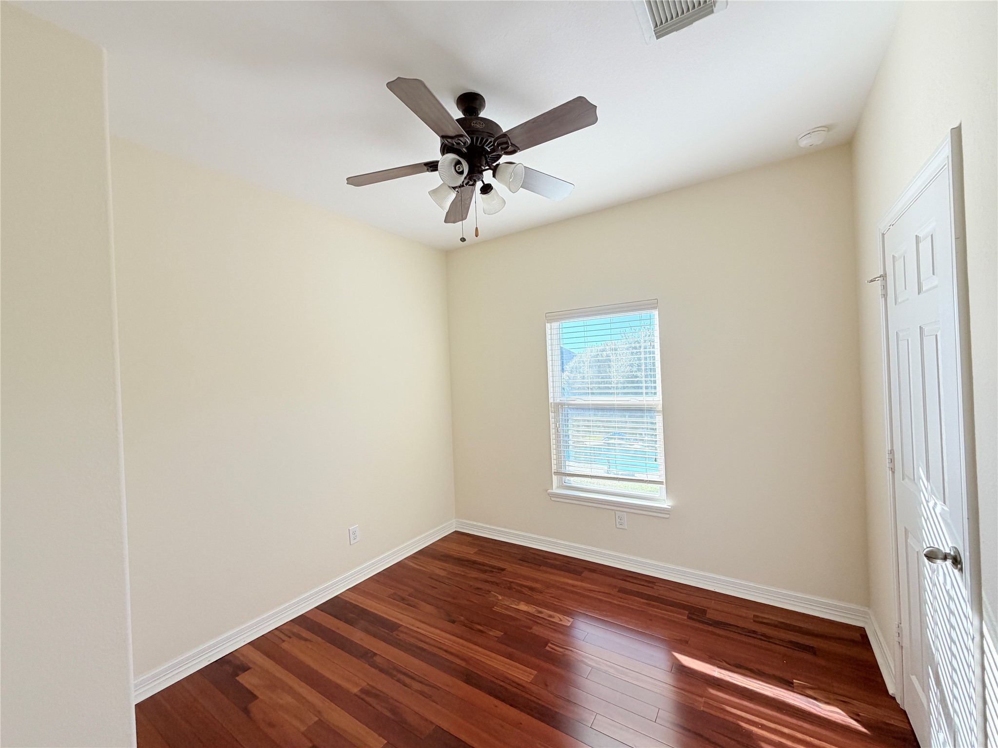 28015 Silverstream Court Fulshear, TX 77441 - Photo 30 of 33 an empty room with wooden floor fan and windows