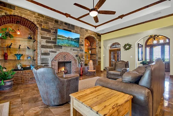 a living room with furniture a large window and a fireplace